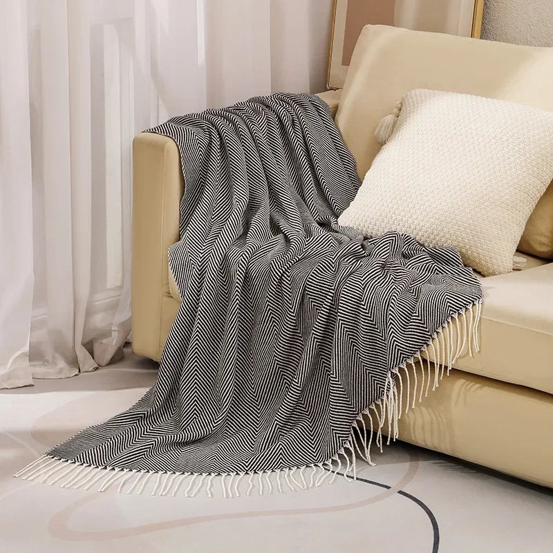 Kuschelige Wurfdecke mit nordischem Design auf einem Sofa