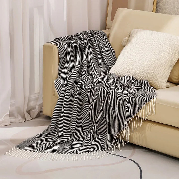Kuschelige Wurfdecke mit nordischem Design auf einem Sofa