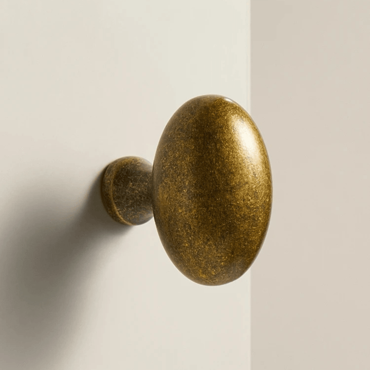 Möbelknopf aus massivem Messing mit antikem Finish an einer Schranktür