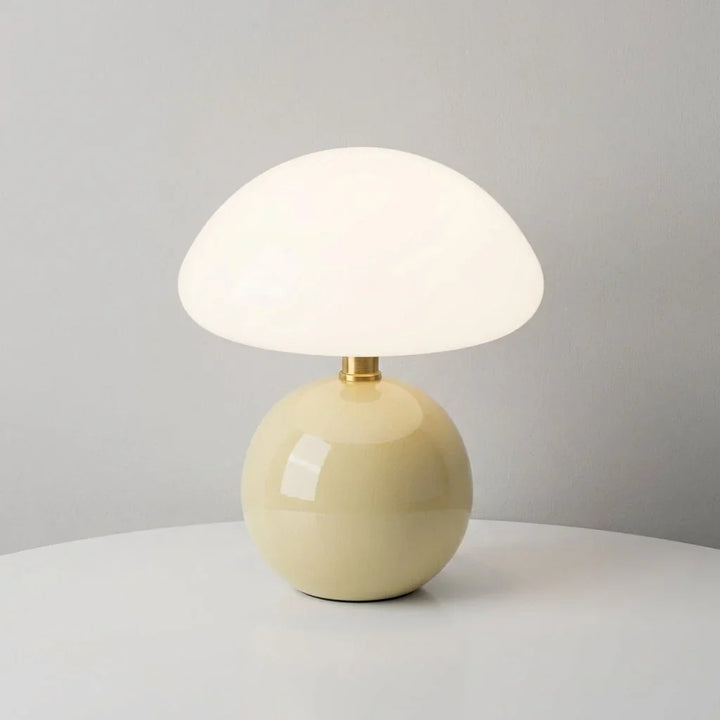 Pilzförmige Tischlampe mit Kuppelschirm und runder Basis auf einem Schreibtisch