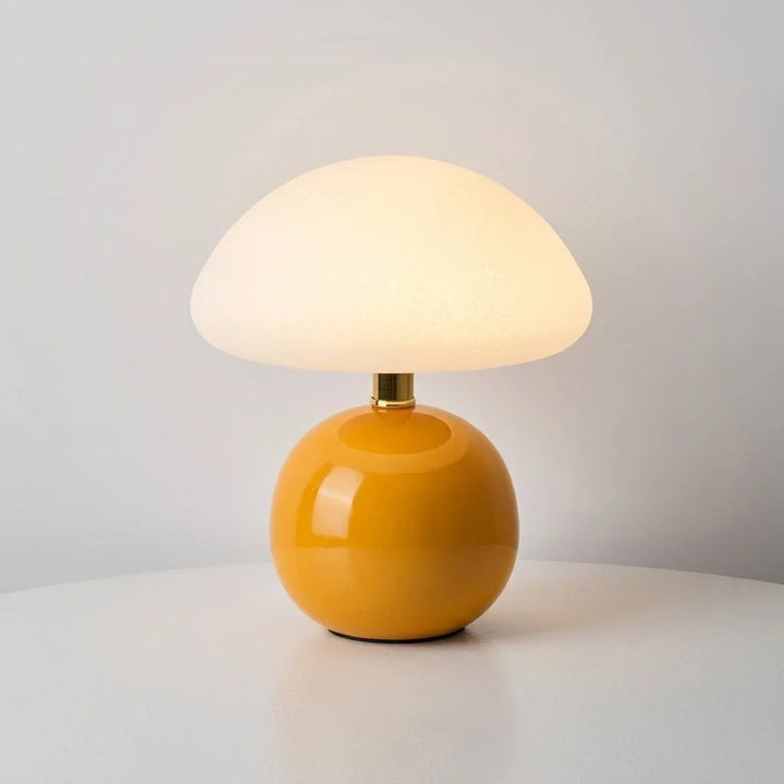 Pilz-Tischlampe mit rundem Lampenfuß neben Schreibtischzubehör